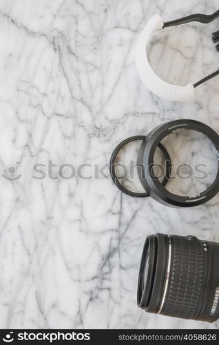 elevated view camera lens accessories marble textured background