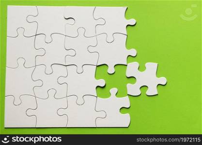 elevated view cardboard puzzle green background. High resolution photo. elevated view cardboard puzzle green background. High quality photo