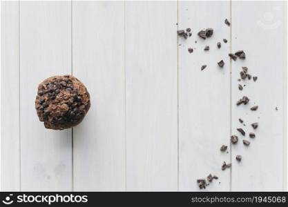 elevated view choco chip cupcake scattered chocolate wooden background. High resolution photo. elevated view choco chip cupcake scattered chocolate wooden background. High quality photo