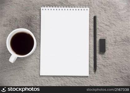 elevated view coffee cup blank spiral notepad with black eraser pencil gray desk