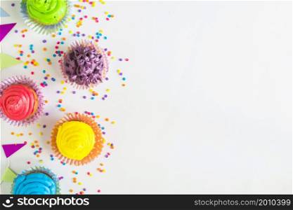 elevated view colorful muffins bunting white surface