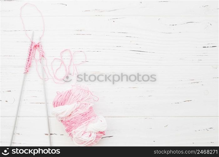 elevated view crochet with pink yarn wooden backdrop
