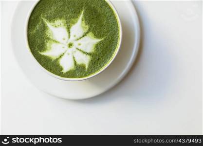 elevated view delicious matcha latte flower art cup saucer white background