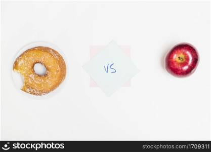 elevated view donut versus apple white surface