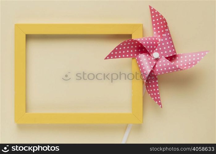 elevated view dotted pinwheel yellow frame beige background