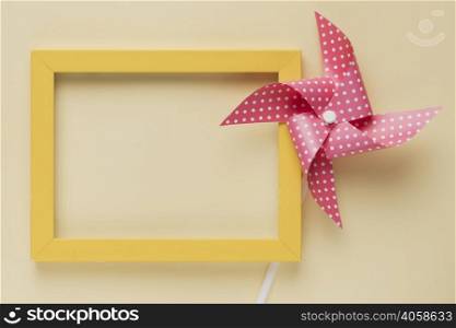 elevated view dotted pinwheel yellow frame beige background
