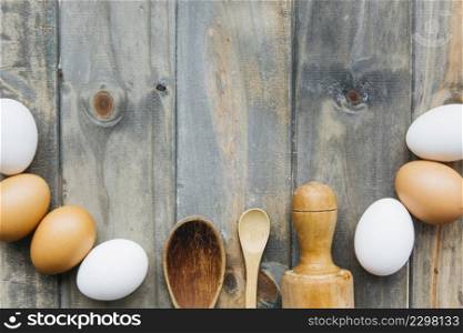 elevated view eggs with rolling pin spoon wooden backdrop