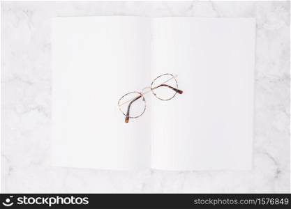 elevated view eyeglasses blank white paper marble background