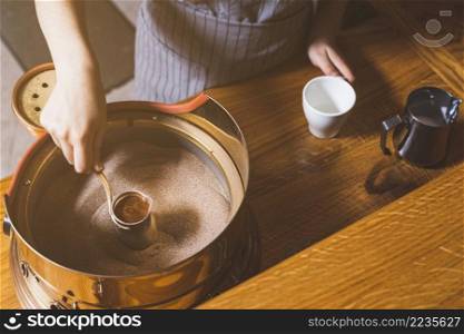 elevated view female hand making turkish coffee sand caf