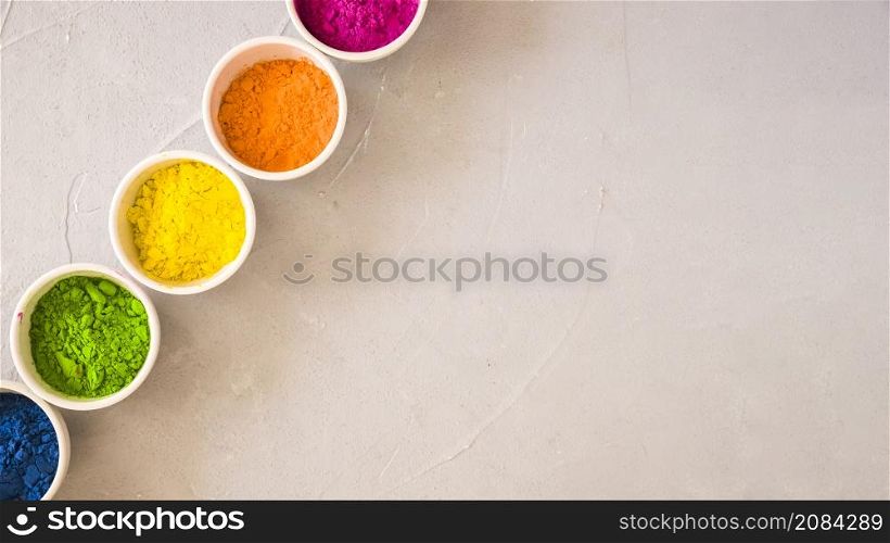 elevated view holi color powder white bowls concrete background