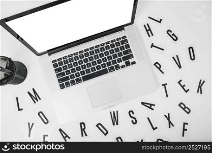 elevated view laptop with various alphabets white background