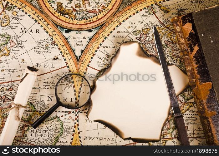elevated view magnifying glass burnt paper knife map. Resolution and high quality beautiful photo. elevated view magnifying glass burnt paper knife map. High quality beautiful photo concept