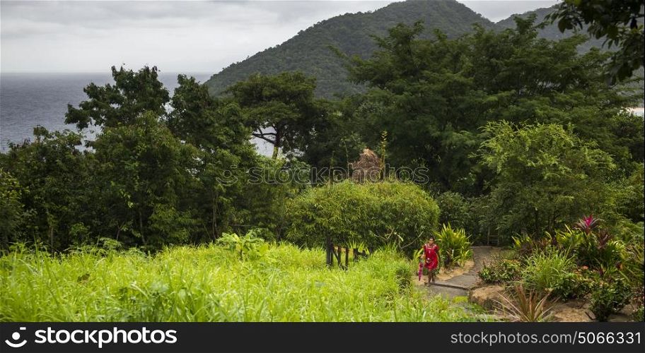 Elevated view of woman walking on a hillside footpath, Yelapa, Jalisco, Mexico