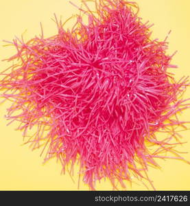 elevated view pink pom pom yellow background