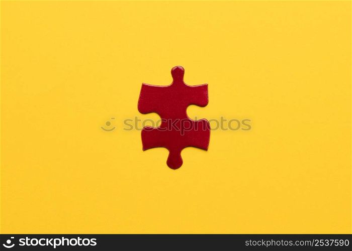 elevated view red jigsaw puzzle piece yellow backdrop