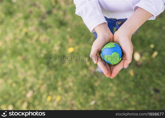 elevated view small clay globe cupped hands grass. Resolution and high quality beautiful photo. elevated view small clay globe cupped hands grass. High quality beautiful photo concept