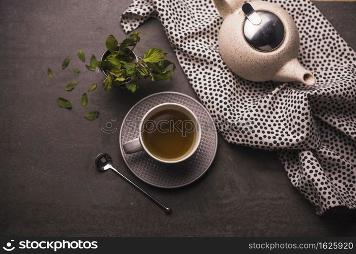 elevated view tea leaves teapot polka dotted textile table