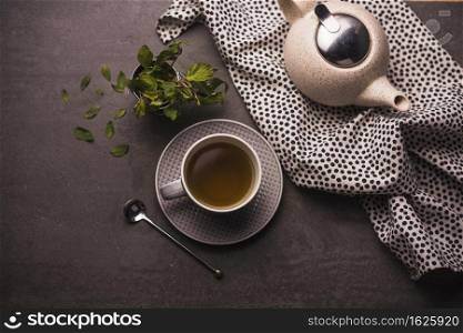 elevated view tea leaves teapot polka dotted textile table