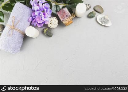 elevated view towel candles scrub bottle flowers spa stones grey backdrop. High resolution photo. elevated view towel candles scrub bottle flowers spa stones grey backdrop. High quality photo