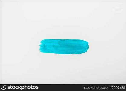 elevated view turquoise watercolor brush stroke white sheet paper