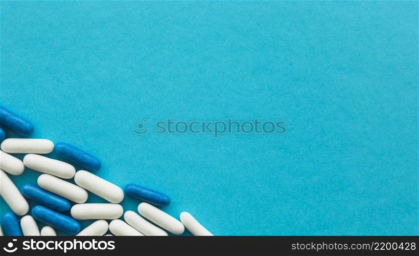 elevated view white blue candy capsules corner cyan backdrop