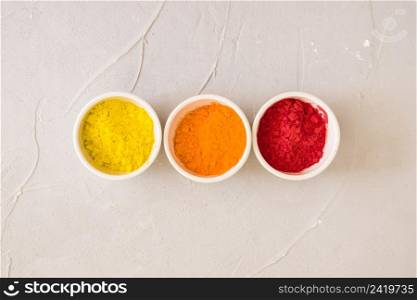 elevated view white bowls with holi color powder simple background