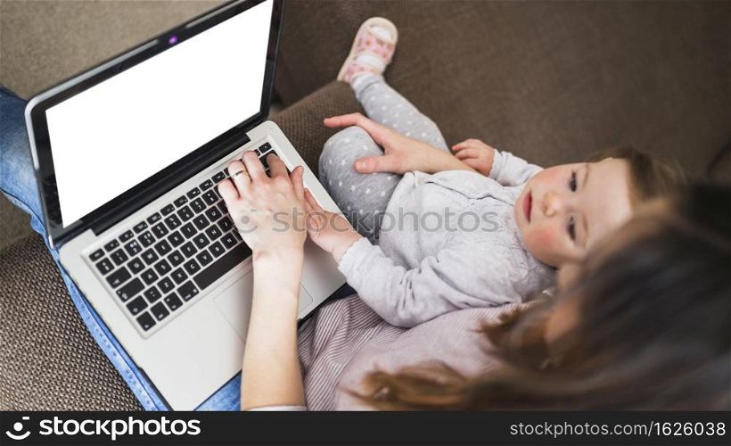 elevated view woman with her daughter using laptop with blank white screen