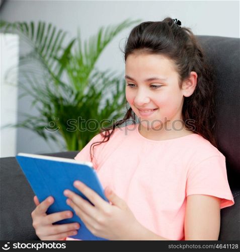 Eleven year old girl playing with a tablet on her couch