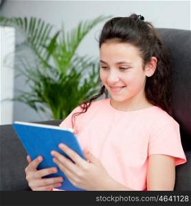 Eleven year old girl playing with a tablet on her couch