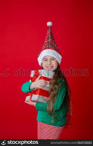 Elf girl with gifts, Santa Claus helper on a bright red bright colored background. Portrait of a beautiful elven baby. Copy space.. Greedy gnome. Elf girl with gifts, Santa Claus helper on a bright red bright colored background. Portrait of a beautiful elven baby.