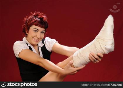 Elfin girl with punk red hair show off her bandaged foot