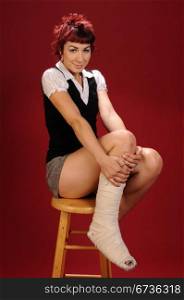 Elfin girl with punk red hair show off her bandaged foot