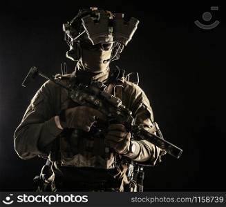 Elite commando fighter, private military company mercenary, special operations serviceman, security or secret service shooter equipped modern weapons and ammunition, studio shoot on black background. Military security service shooter soldier studio portrait