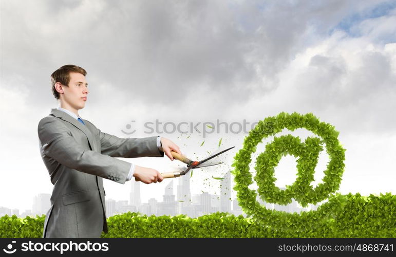 Email concept. Businessman cutting green bush. Network and e-commerce