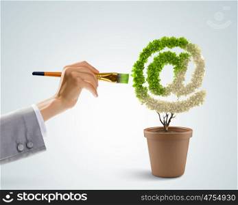 Email concept. Close up image of human hand painting plant