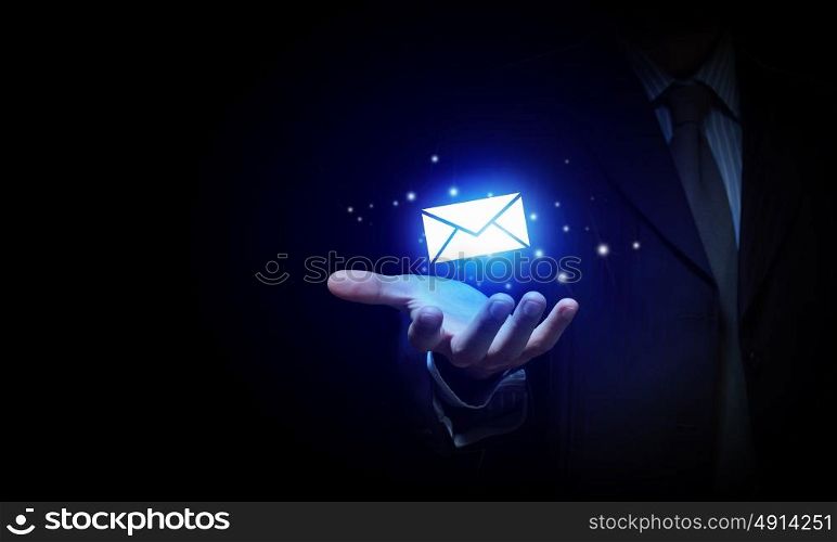 Email concept. Close up of businessman holding email icon in palm
