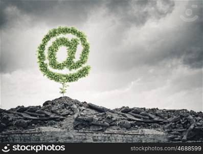 Email concept. Conceptual image with at symbol growing on ruins