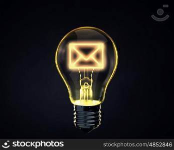 Email concept. Light bulb with mail sign inside on dark background