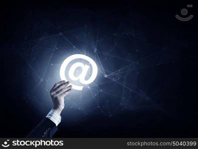 Email digital concept. Businessman hand on dark digital background showing email sign
