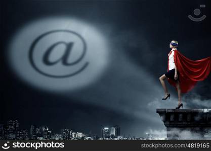 Email symbol as concept. Young woman super hero and email sign in spotlight