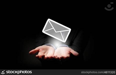 Email symbol. Close up of businessman hand holding email sign