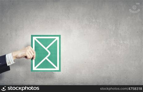 Emailing. Hand holding envelope card representing email concept