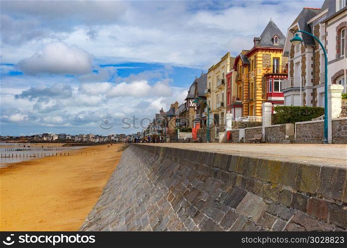 Embankment and beach, Saint-Malo, Brittany, France. High stone embankment and beach at low tide, in beautiful walled port city of Privateers Saint-Malo, also known as city corsaire, Brittany, France