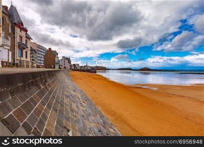 Embankment and beach, Saint-Malo, Brittany, France. High stone embankment and beach at low tide, in beautiful walled port city of Privateers Saint-Malo, also known as city corsaire, Brittany, France