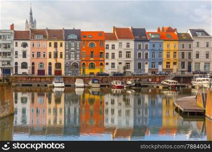 Embankment of the river Leie with reflections colored houses and Belfry tower in Ghent town, Belgium