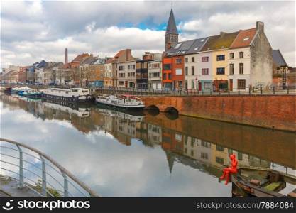 Embankment of the river Leie with reflections colored houses and Belfry tower in Ghent town, Belgium