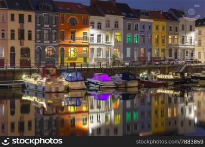 Embankment of the river Leie with reflections colored houses in Ghent town at night, Belgium