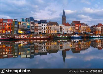 Embankment of the river Leie with reflections colored houses in Ghent town at sunset, Belgium
