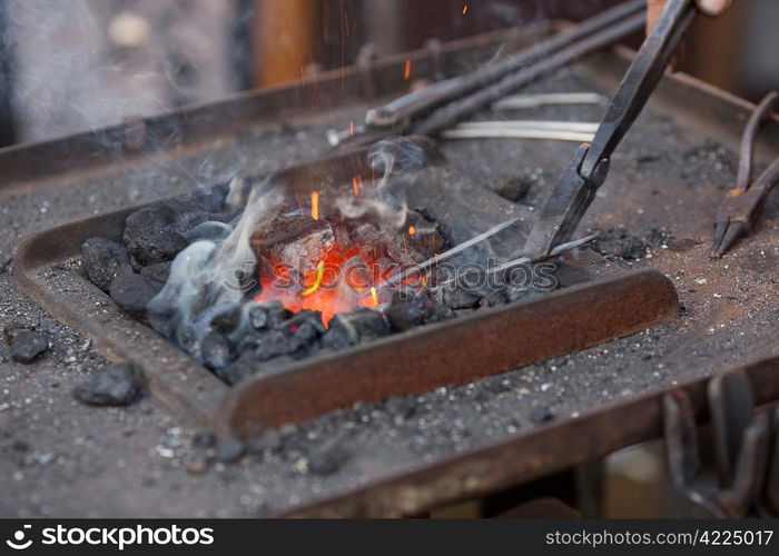 embers, fire, smoke and blacksmith tools