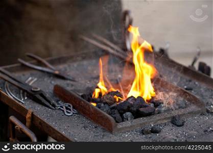 embers, fire, smoke and blacksmith tools